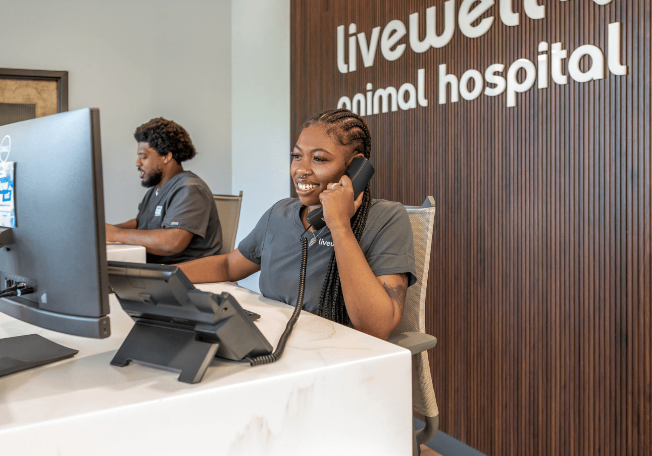 Two receptionists working at their desks, answering phone calls.